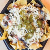 Grilled Chicken Nacho · Chips piled with queso, black beans, pico de gallo, Monterey Jack cheese, jalapeños, and gri...