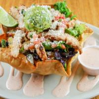 Chipotle Chicken Taco Salad · Hand fried flour tortilla bowl loaded with mixed greens, black beans, and corn. Topped with ...
