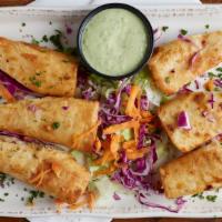 Mini Chimis De Cameron · Mini-chimichangas filled with seasoned grilled shrimp and cheese. Served with our spicy avoc...