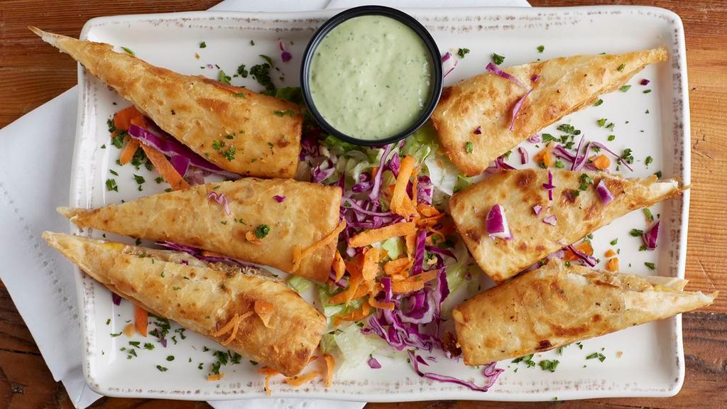 Mini Chimis De Cameron · Mini-chimichangas filled with seasoned grilled shrimp and cheese. Served with our spicy avocado cream dipping sauce.