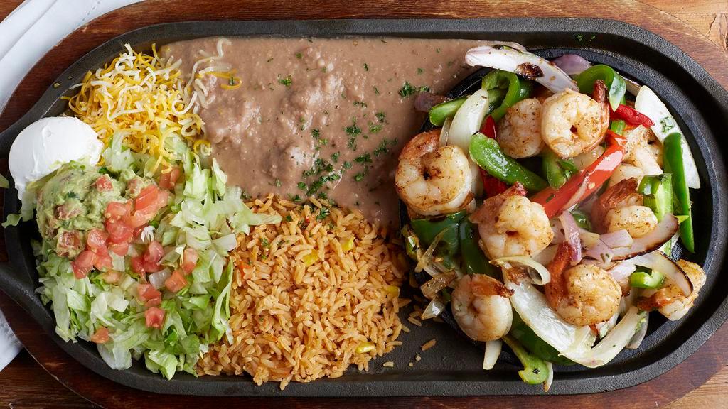 Shrimp Fajita · Succulent shrimp specially seasoned. Grilled and served sizzling with red and green bell peppers, tomatoes and onions. With shredded cheese, lettuce, fresh guacamole, sour cream, Mexican rice, re-fried beans and soft, fresh-made tortillas.