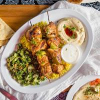 Chicken Kabobs · Two skewers of char-broiled chicken breast served over rice with a side of garlic sauce for ...