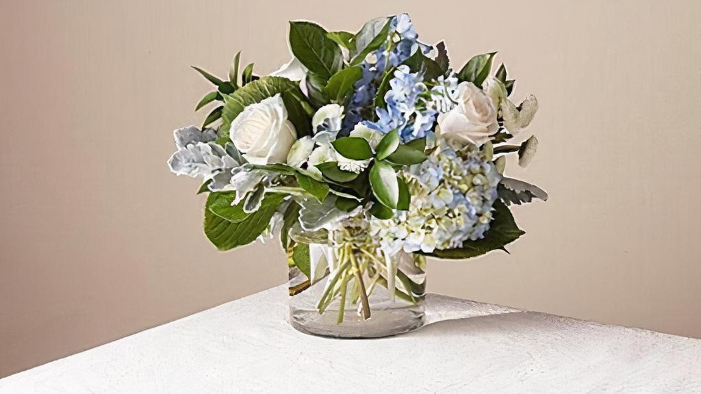 Clear Skies Bouquet · Let this uplifting arrangement be reminders of the clear skies ahead. Capturing the feeling of hope that a new day brings, this bouquet is composed of voluminous hydrangea blooms and vibrant belladonna delphinium to refresh their mood. Vase included. Please Note: The bouquet pictured reflects our original design for this product. While we always try to follow the color palette, we may replace stems to deliver the freshest bouquet possible. Item # NFGS
