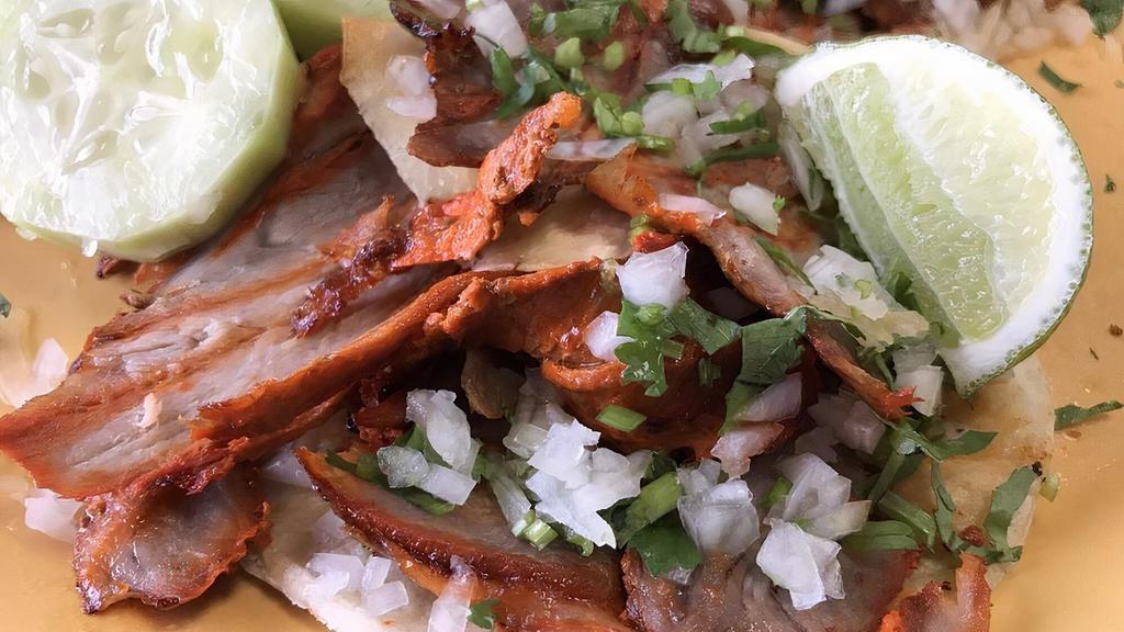 The Original Taco Al Pastor · Our signature marinated pork taco! Two corn tortillas, topped with sliced pineapple, onions and cilantro.
