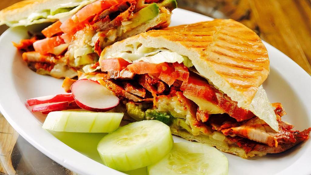 Mexican Sandwich · Tasty, hot & crispy. Mexican style sub bread with melted mozzarella cheese, tomatoes, mayo, lettuce, refried beans, onions and sliced avocados.