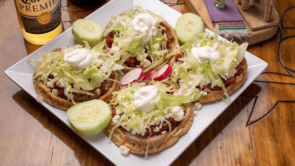 Sopes · Sopes are made from the same corn dough used to make tortillas, only these are ticker topped with refried beans, your choice of meat, sheredded lettuce queso fresco and sourcream.