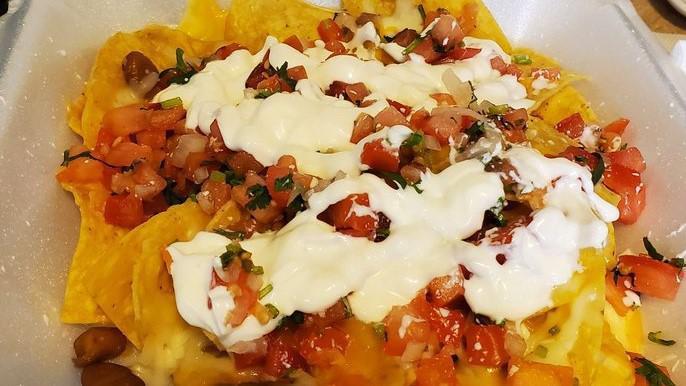 Nachos · Crisp nachos topped with melted mozzarella cheese and served with pico de gallo and sour cream.