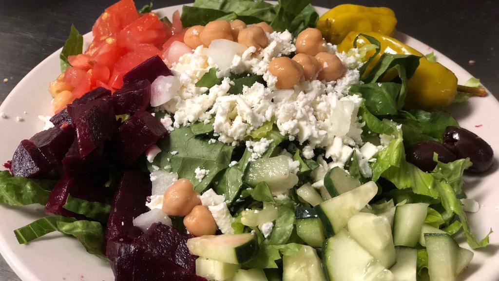 Greek Salad · Gluten free. Chopped romaine lettuce, feta cheese, fresh roasted beets, sweet onions, garbanzo beans, mild pepper rings, kalamata olives, tomatoes & cucumbers. served with our famous house-made dressing.