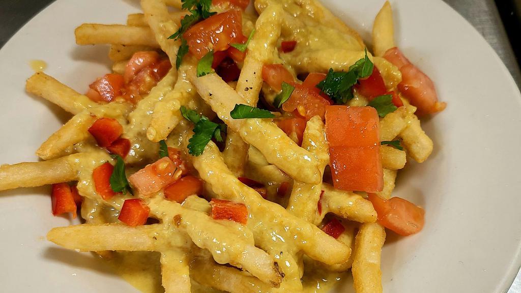 Curry Fries · Crispy fries covered in sweet curry sauce and topped with red peppers, green onions and diced tomatoes with cilantro.