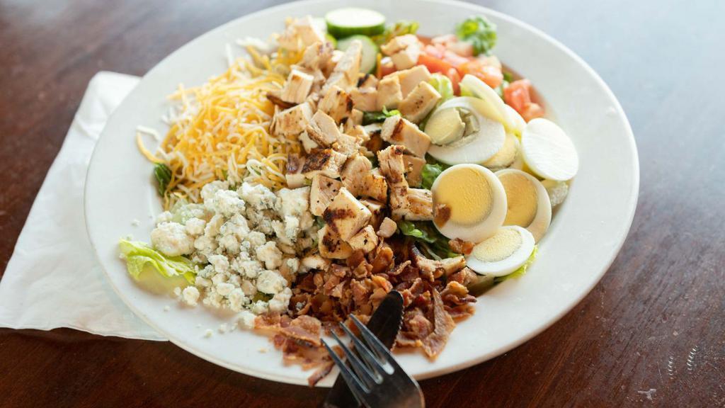Cobb Salad · Fresh cut Romaine lettuce topped with grilled chicken, bleu cheese, smoked bacon, cucumbers, tomato, hard-boiled egg and mixed cheese.
