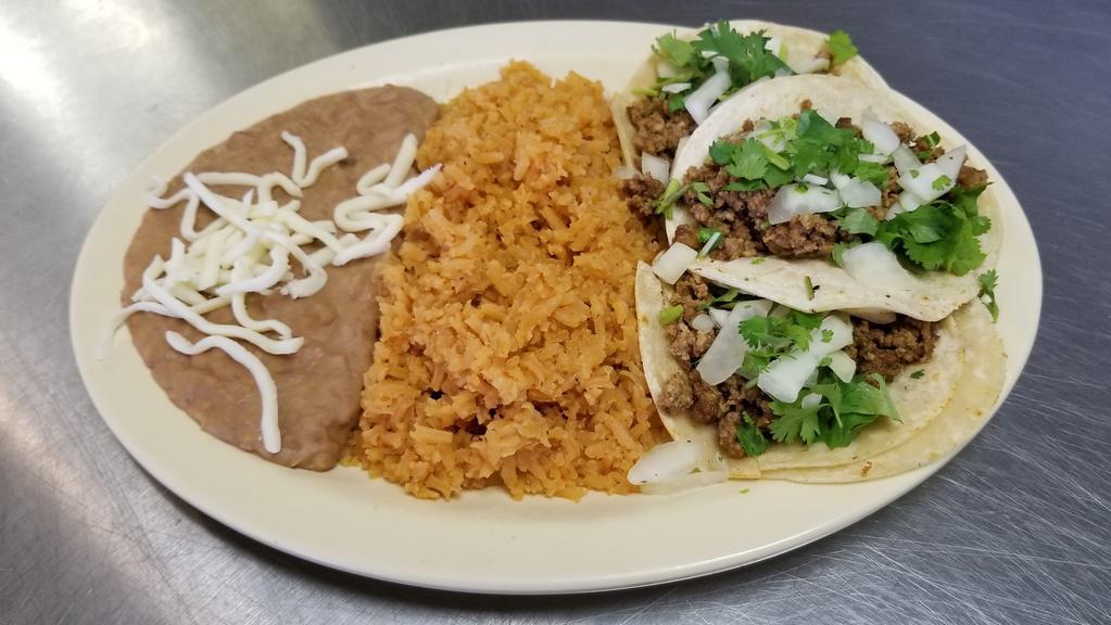Taco Dinner · Three soft corn shell tacos stuffed with choice of meat, along with onions and cilantro, served with rice and beans.