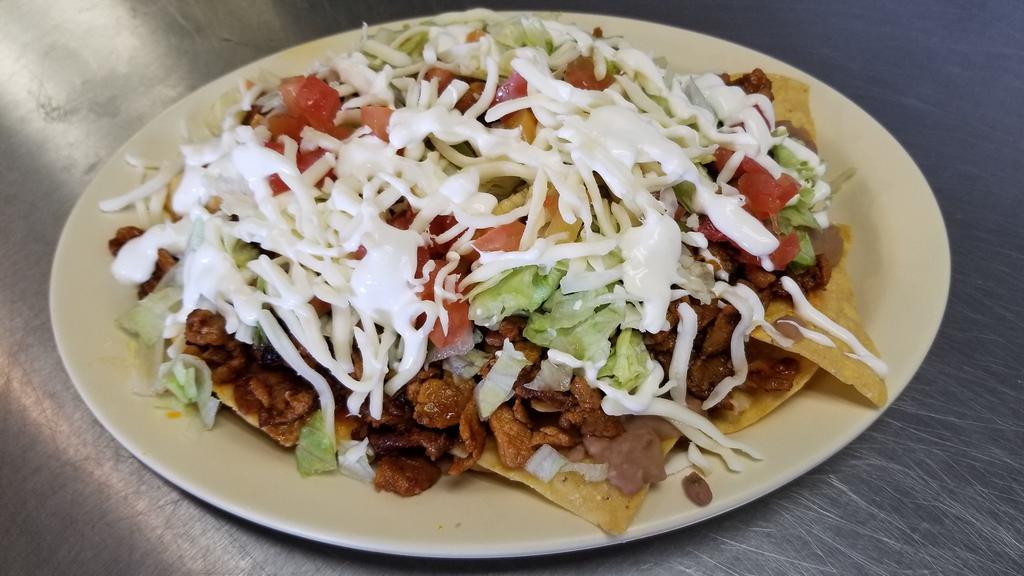 Nachos · Fresh nacho chips topped with choice of meat, along with beans lettuce, cheese, tomatoes, and sour cream.
