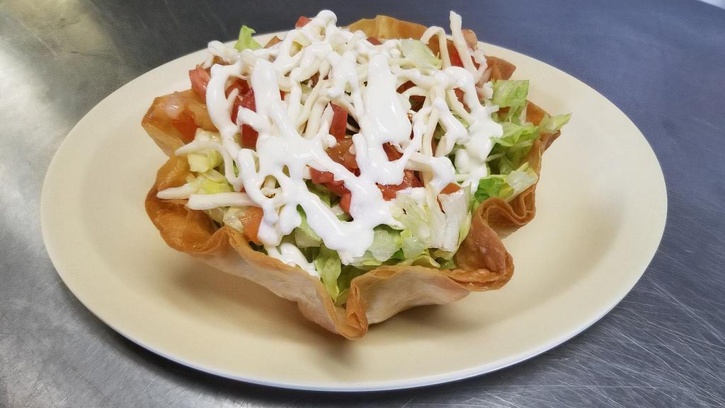 Taco Salad · Crispy tortilla shell filled with ground beef or chicken beans, lettuce cheese, tomatoes, and sour cream.