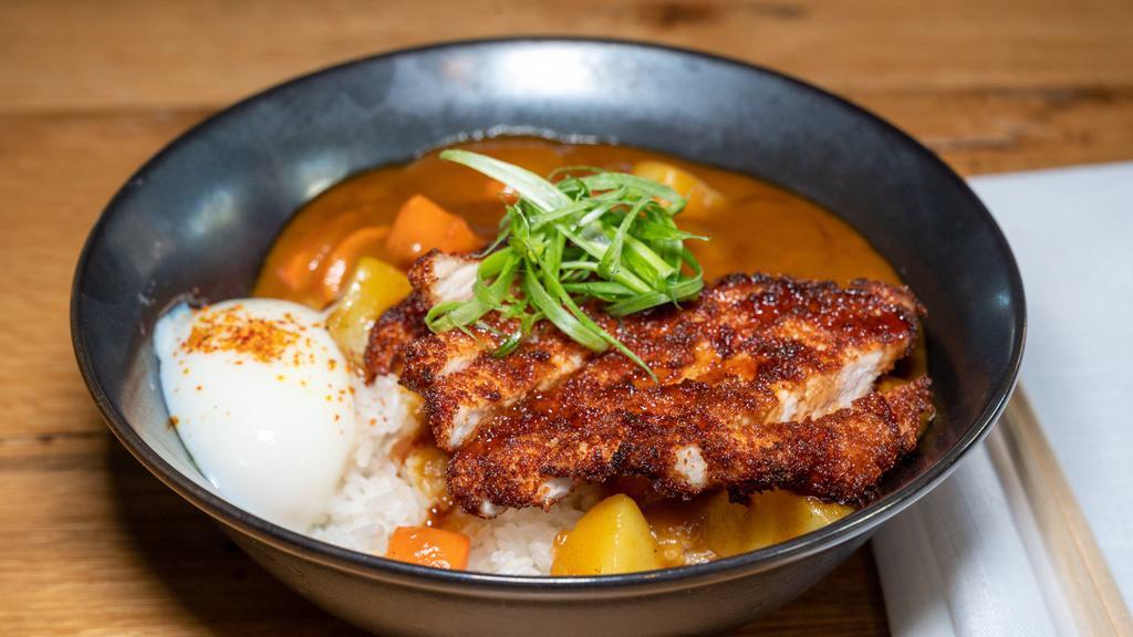 Curry Katsudon · Crispy pork over rice with potatoes, carrots, poached egg, and tonkatsu sauce.