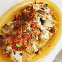 Nachos · Thick blend corn tortilla chips dipped in refried beans and topped with a layer of chihuahua...