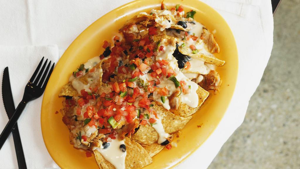 Nachos · Thick blend corn tortilla chips dipped in refried beans and topped with a layer of chihuahua cheese. Also served with pico de gallo, sour cream, and fresh guacamole.