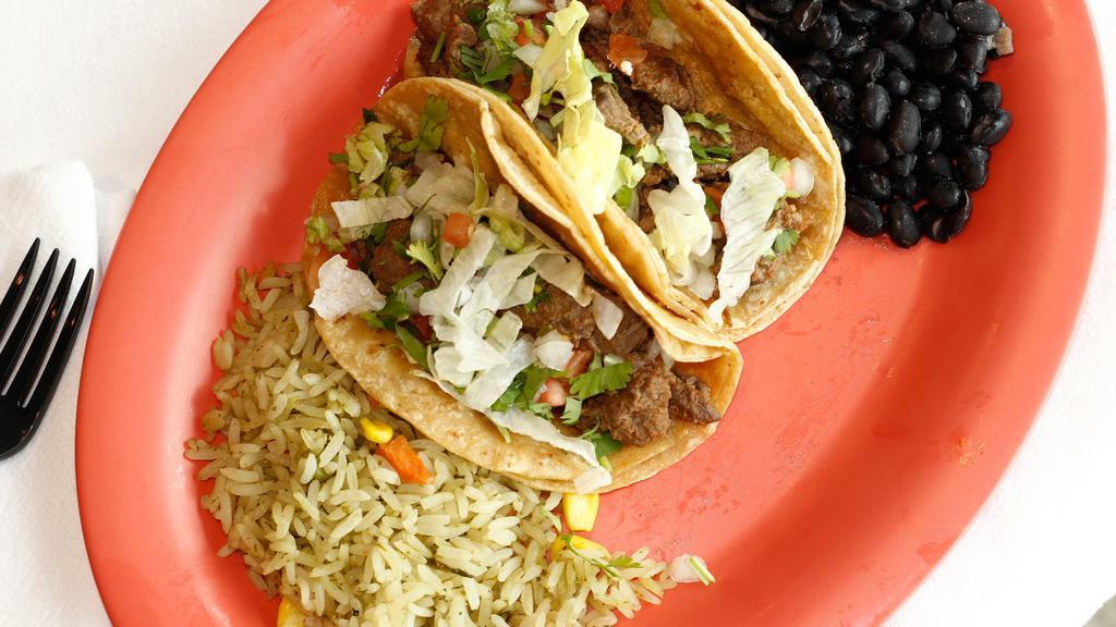 Taco Dinner · Three tacos with your choice of ground beef, chicken, pork (al pastor), shredded beef (desebrada), or chopped steak. Topped with lettuce, tomato and cheese. Served with a side of Spanish rice and refried beans.