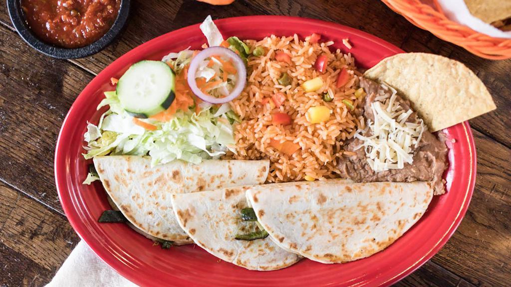Quesadillas Con Rajas · Our version of this south of the border favorite consists of three folded-over corn or flour tortillas filled with melted chihuahua cheese, grilled onions, and poblano peppers. Accompanied with Spanish rice, refried beans, and salad.