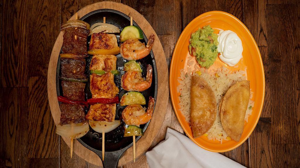 Banderillas · Three assorted skewers of skirt steak, chicken breast and shrimp. Served with white rice, guacamole, sour cream, and two shrimp and cheese empanadas.