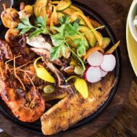 Cancun Skillet · A seafood combination skillet featuring: grilled octopus, a shrimp skewer, tilapia fillet, a...