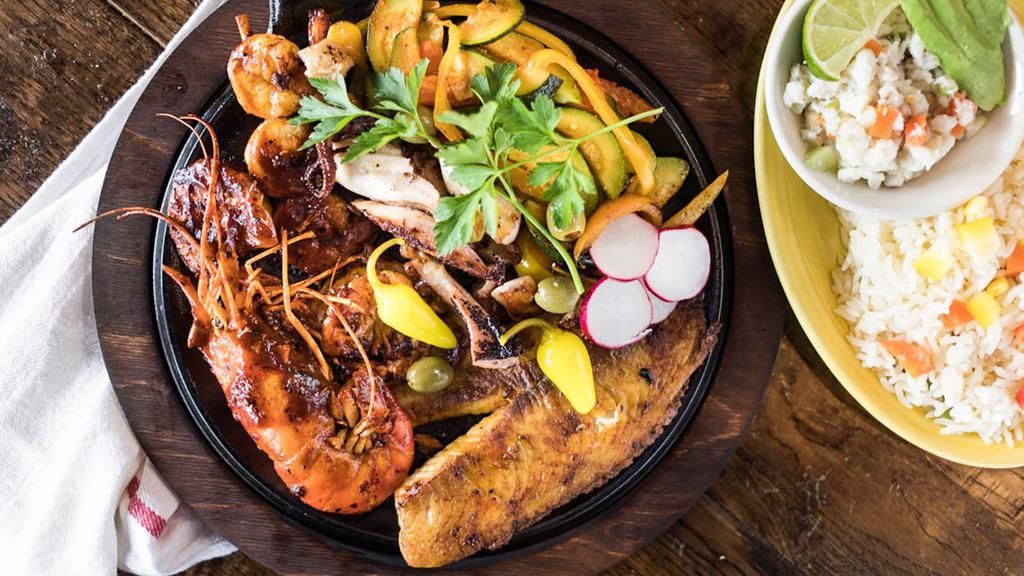 Cancun Skillet · A seafood combination skillet featuring: grilled octopus, a shrimp skewer, tilapia fillet, and jumbo shrimp. Served with grilled vegetables on a hot skillet along with a side of tilapia ceviche and a side of white rice. Sorry, no substitutions, please.