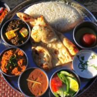 Harvest Thali · A vegetarian sampler of Saag Paneer, Baingan Bharta, and Dal Makhani, served with Basmati Ri...