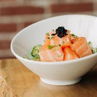 Salmon Poké · Marinated cubed salmon on a bed of cucumber salad topped with black tobiko.