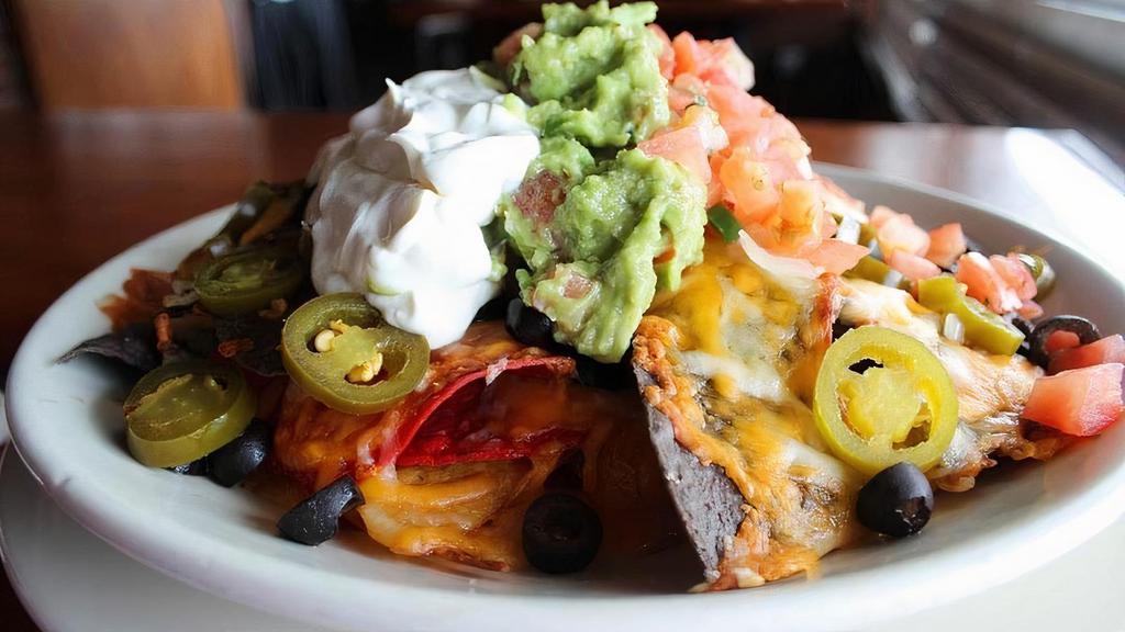 Ultimate Nachos · Crispy corn tortilla chips piled high with seasoned refried beans, homemade chili, jalapeño peppers, melted Chihuahua & Cheddar cheese, black olives, sour cream, pico de gallo & guacamole.