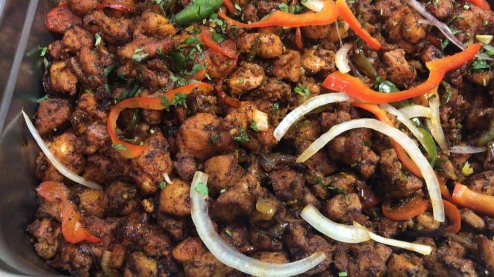 Spicy Pepper Chicken · Cubed chicken stir-fried with curry leaves and green chilies in a zesty black pepper sauce.