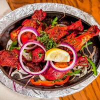 Tandoori Chicken · Chicken marinated in yogurt, ginger garlic paste with special herbs and spices. Cooked on sk...