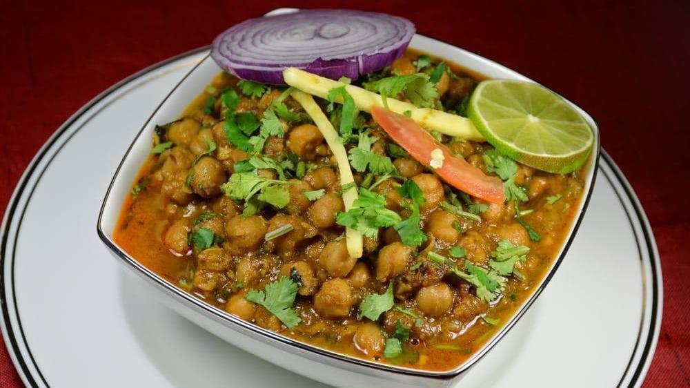 Chana Masala · Zesty garbanzo bean curry with sauteed onions, tomatoes, garlic, and ginger, garnished with cilantro. Served with basmati rice.