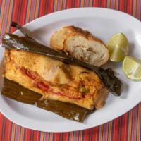 Tamal Guatemalteco · Corn tamale with pork, olives, red pepper, steamed in a banana leaf.