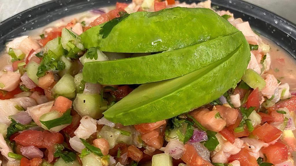 Ceviche De Pescado · Fresh tilapia marinated in lime juice mixed with cucumbers, tomatoes, red onions, cilantro and avocados, served cold with our special house sauce.
