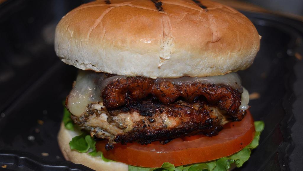 Yardie  Chicken Sandwich · Grilled Jerk chicken breast. Served on a bun. Topped with caramelized onion, lettuce, tomatoes, ripe plantain and cheddar cheese. Served with your choice of fries or sweet plantains and sauce.