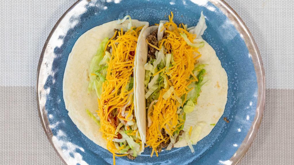 Soft Tacos · Garnished with lettuce, Texas sauce, diced onions and cheddar cheese