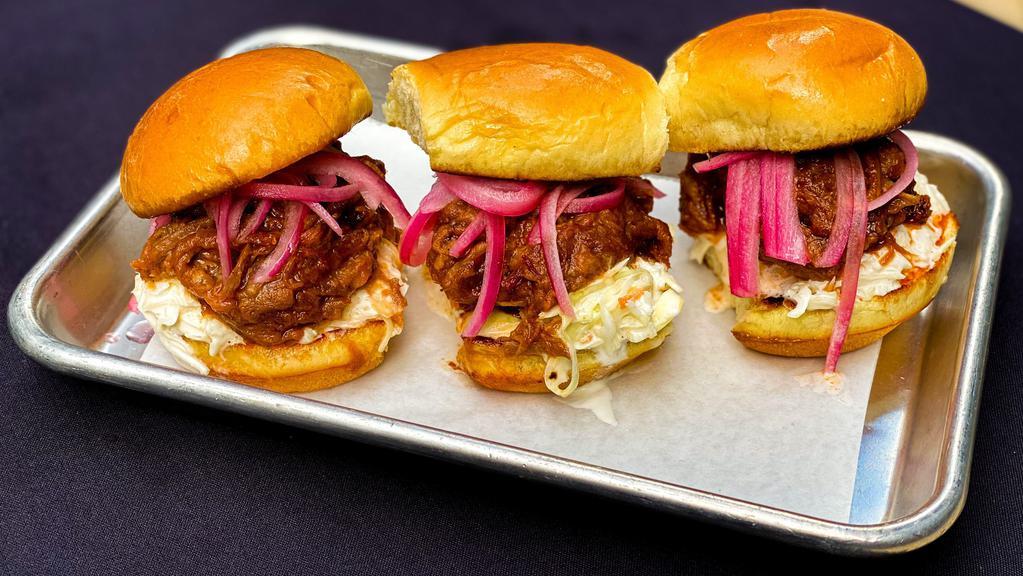 Brisket Sliders · Three chopped brisket sliders, tossed in our Texas Mop BBQ sauce, topped with coleslaw and pickled onions and served on brioche buns.