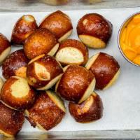 Pretzel Bites · Soft pretzel bites, tossed in kosher salt and served with warm cheese sauce for dipping.