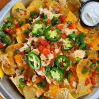 Chicken Nachos · Crisp tortilla chips smothered with our black bean dip, fresh salsa, jalapeños and melted ch...