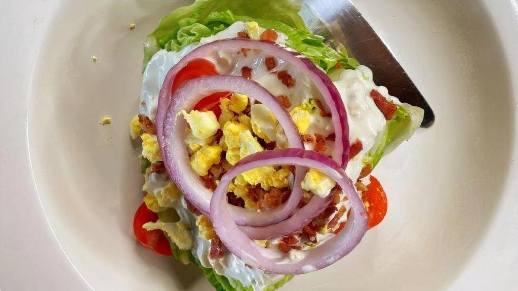 The Wedge  · An iceberg wedge with blue cheese dressing topped with bacon, tomato, egg and fresh red onion.