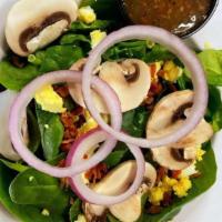 Spinach Salad · Baby spinach topped with mushrooms, bacon, chopped egg and fresh red onion. Served with hot ...