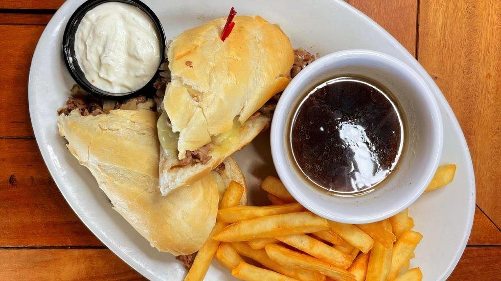 French Dip · Shaved tender sirloin topped with sautéed onions and melted  Swiss cheese on a hoagie, served with hot au jus.