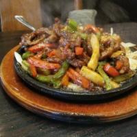 Sizzling Beef · Tender beef stir fried with king oyster mushrooms and red bell peppers in our special sizzli...
