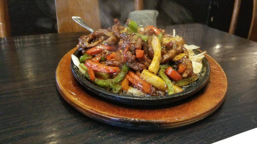 Sizzling Beef · Tender beef stir fried with king oyster mushrooms and red bell peppers in our special sizzling sauce, garnished with steamed broccoli, served sizzling hot on top of stir fried onion at your table.