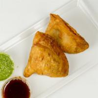 Samosas · Crispy pastry shell stuffed with potatoes, onions, green peas and spices served with tamarin...