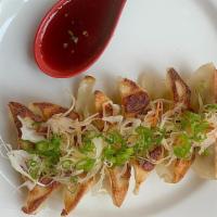 Pork Gyoza (6 Pcs) · Pan-fried pork dumpling topped with homemade spicy sauce and green onions.