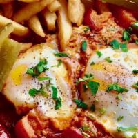 Shakshuka Eggs · Vegan. 
Eggs cooked with tomatoes, onions, and spices, served with sumac fries and pita brea...
