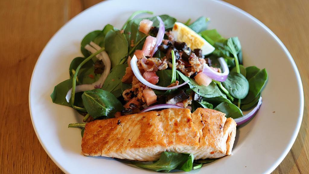 The Salmon And Spinach Salad · Fresh baby spinach, seared salmon, smoked bacon, hard boiled egg, wood fired roasted mushrooms, shaved red onions, and warm bacon dressing