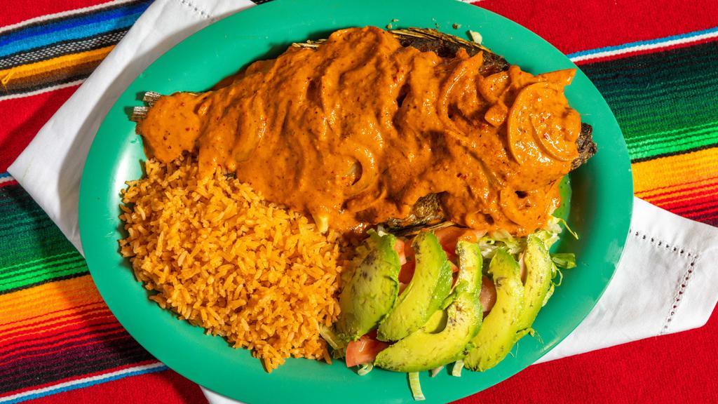 Mojarra La Diabla · Crispy Fried Whole Tilapia Fish covered in our home made Spicy Arbol Sauce. Served with rice and salad.