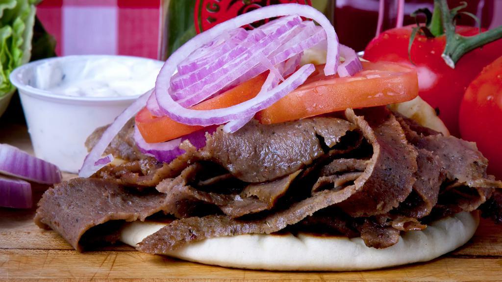 Gyro Or Chicken Pita · Choose between Gyro meat or Marinated Chicken, tomatoes & onions on a pita Tzatziki sauce on the side. Gyro meat in picture.