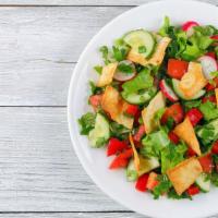 Fattoush Salad · Fresh Romaine, cucumbers, mint, tomatoes, crispy pita chips, and our secret recipe dressing.